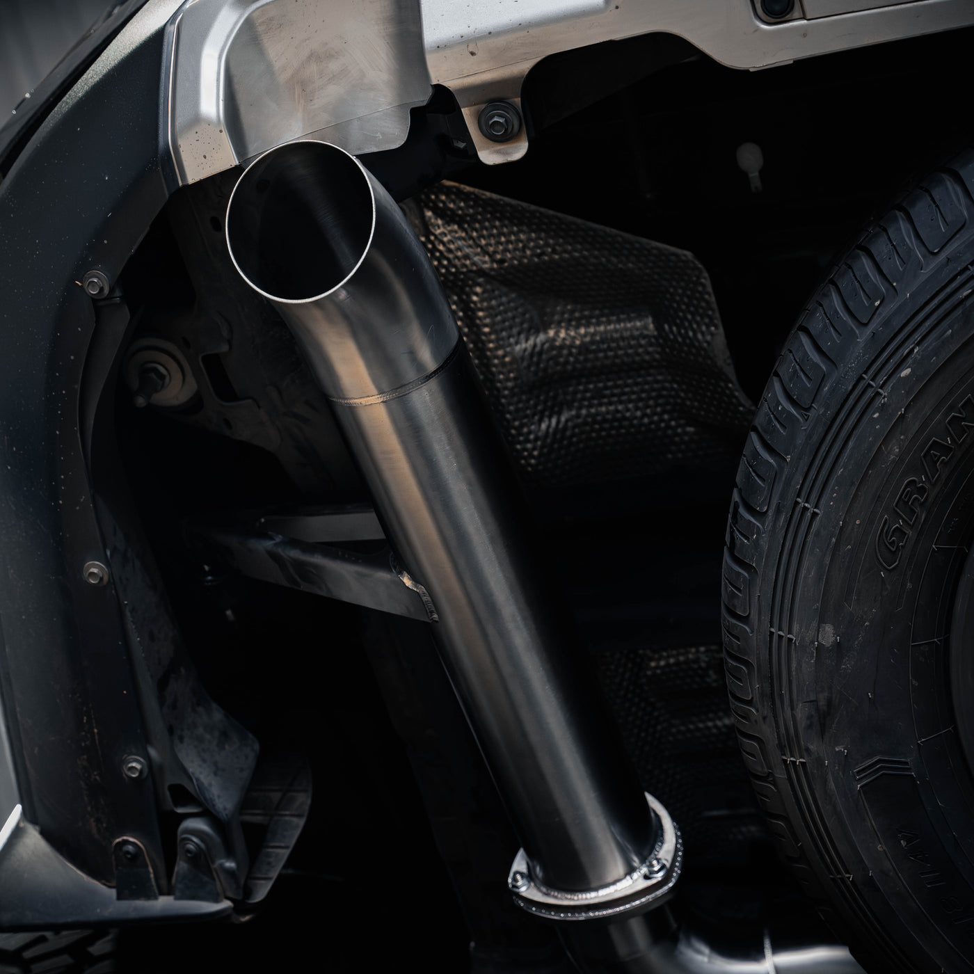 Close-up of a car exhaust system with a visible brand logo.