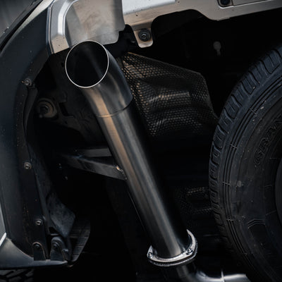 Close-up of a car exhaust system with a visible brand logo.